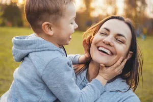 mother and child showing joy outside while smiling