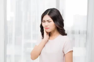 woman holding cheek