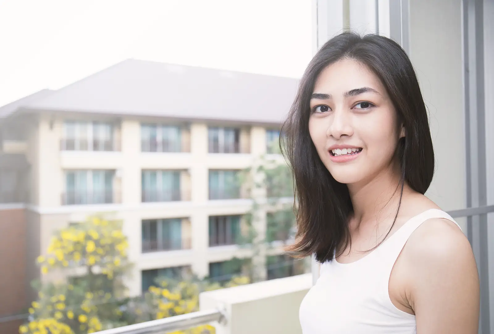 woman smiling next to a window