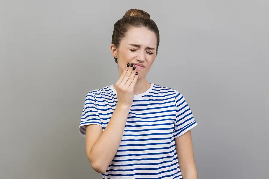 woman with tooth pain and scrunched up face